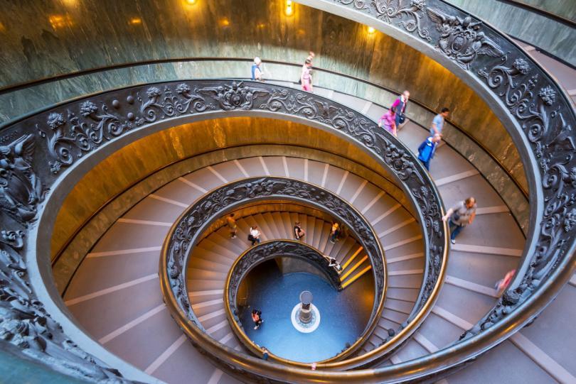 Double spiral stairs in the Vatican Museums, Rome, Italy. View of the old spiral staircase from above. Tourists descend the beautiful spiral stairs.