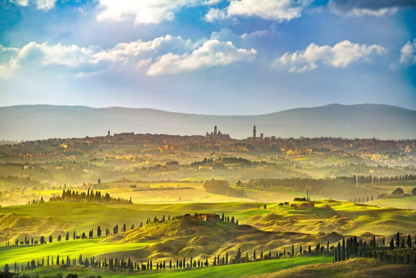 Things to do in Tuscany - Siena city panoramic skyline, countryside and rolling hills in a misty day. Tuscany, Italy, Europe.