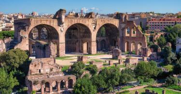 Red stone Basilica of Maxentius with arcs in Rome, Italy