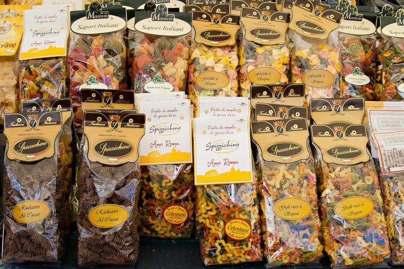 Packaging with colorful and brown pasta on the market Campo dei Fiori.