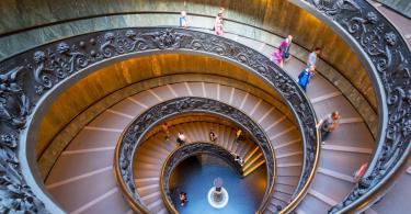 Double spiral stairs in the Vatican Museums, Rome, Italy. View of the old spiral staircase from above. Tourists descend the beautiful spiral stairs.