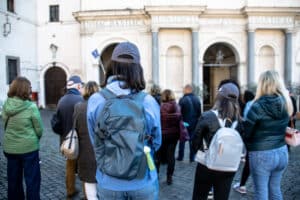 A tour group following a guide through a historic street in Rome, Italy.