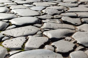 Close-up of uneven ancient cobblestones in the Roman Forum, Rome, Italy.