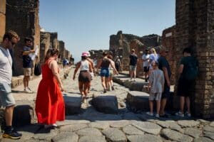 Tourists walking among the ruins of Pompeii on a sunny day