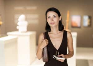 Visitor holding an audio guide device inside a sculpture hall.