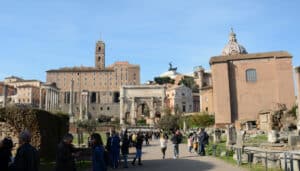 Visitors walking along the Via Sacra in the Roman Forum on a sunny day in Rome